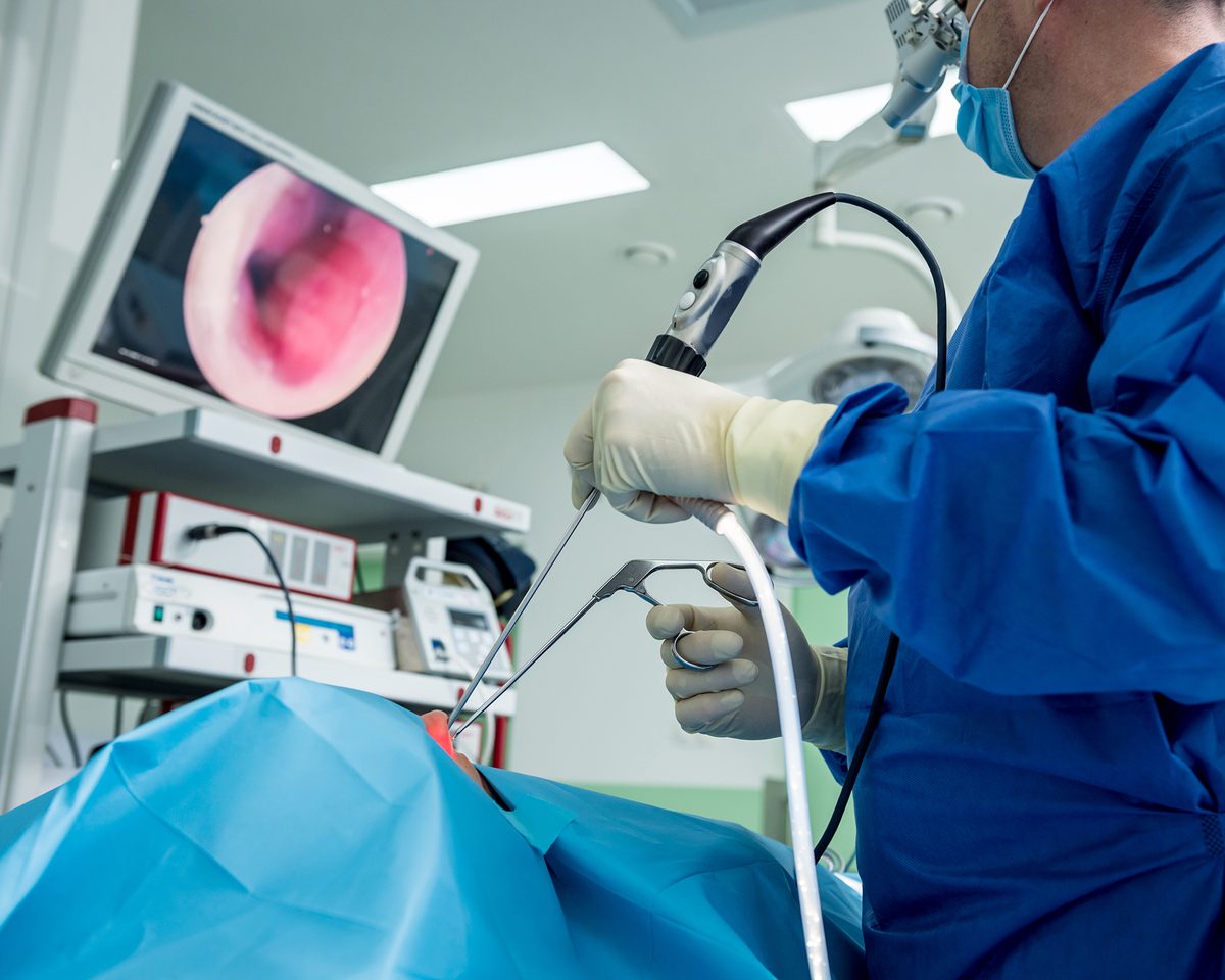 Surgeon performing endoscopic nasal and sinus surgery, with the view on a screen in front of him